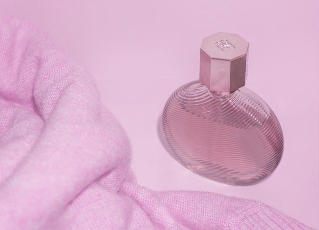 Pink perfume bottle on fabric